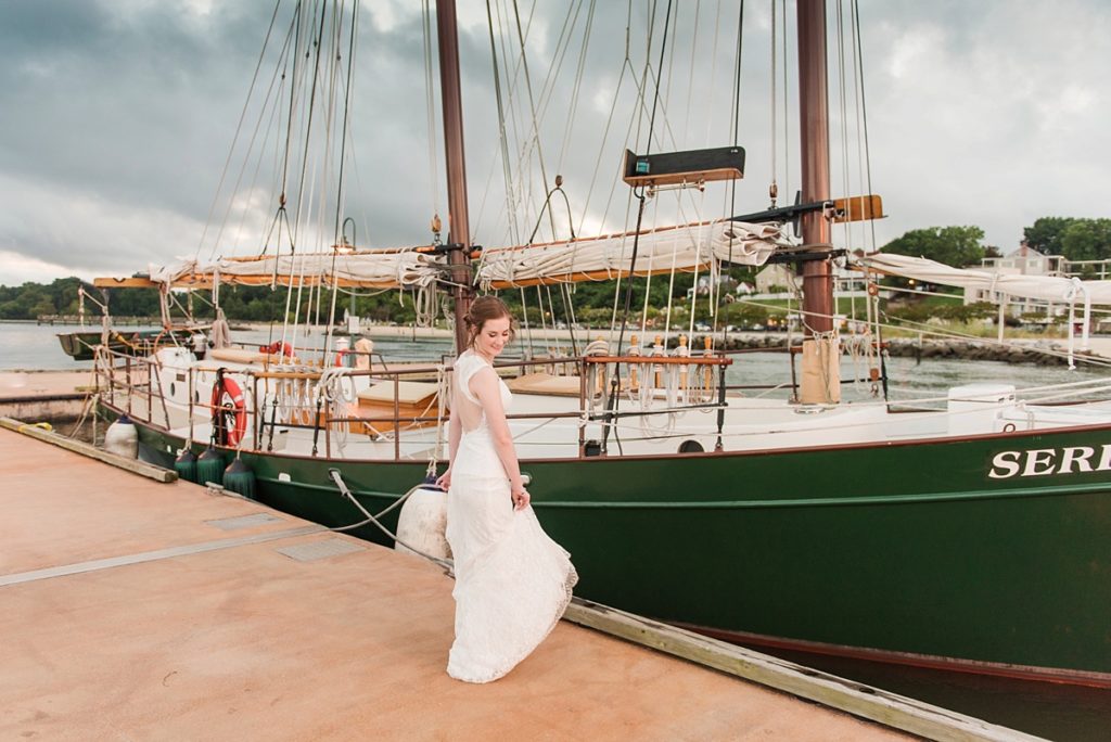 Bride dancing on dock by sail boat