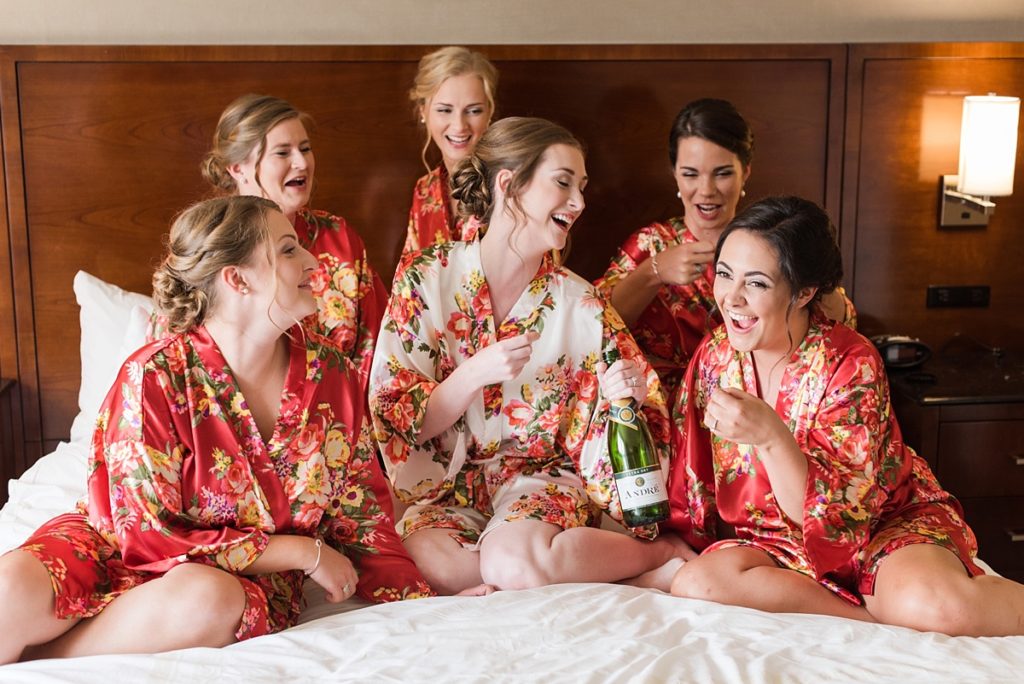 Bridesmaids drinking champagne in bathrobes