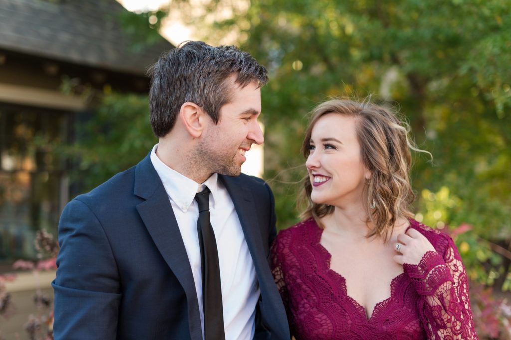 Laughing couple wearing Rent the Runway Red Lace Gown