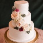Cake under chandelier at garden wedding reception photographed by Meredith Ryncarz