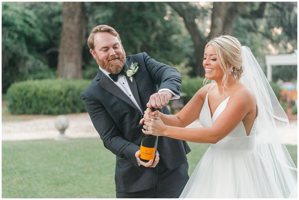 Popping champagne after wedding ceremony on the front lawn in Savannah